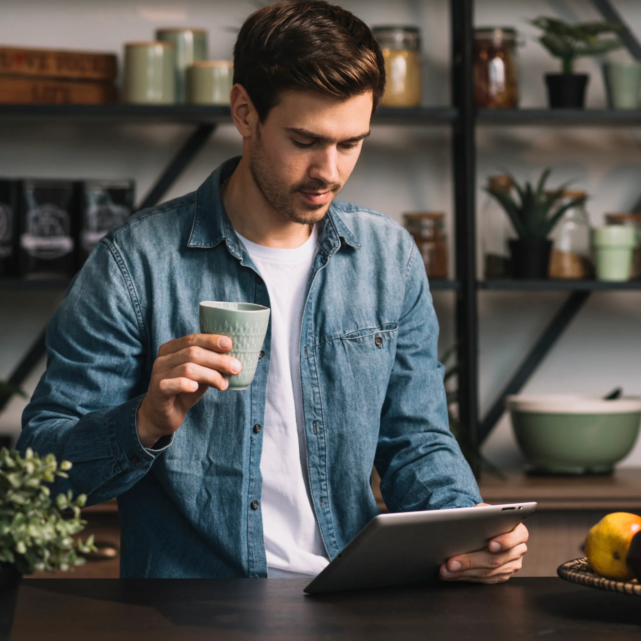Homme consultant sa tablette en buvant un café